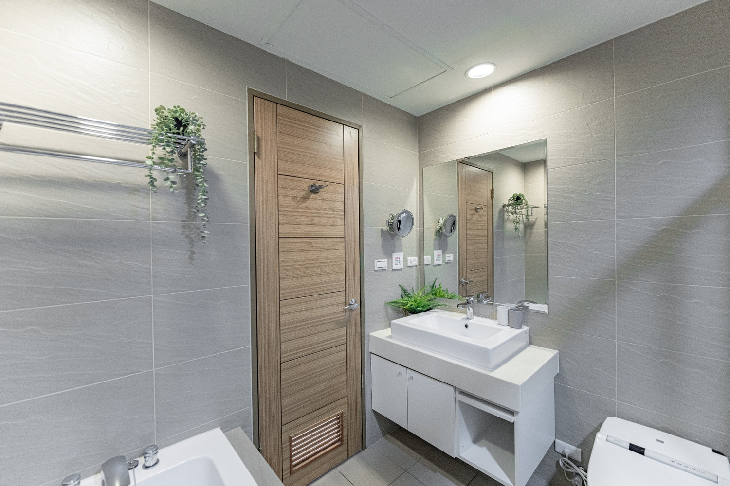 Clean hotel-grade bathroom featuring a rainfall shower/bathtub and Japanese bidet at Kolette Home apartment.
