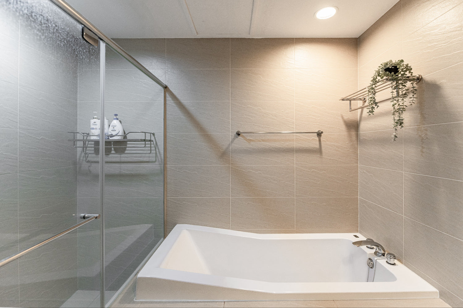Clean hotel-grade bathroom featuring a rainfall shower and Japanese bathtub at Kolette Home apartment.