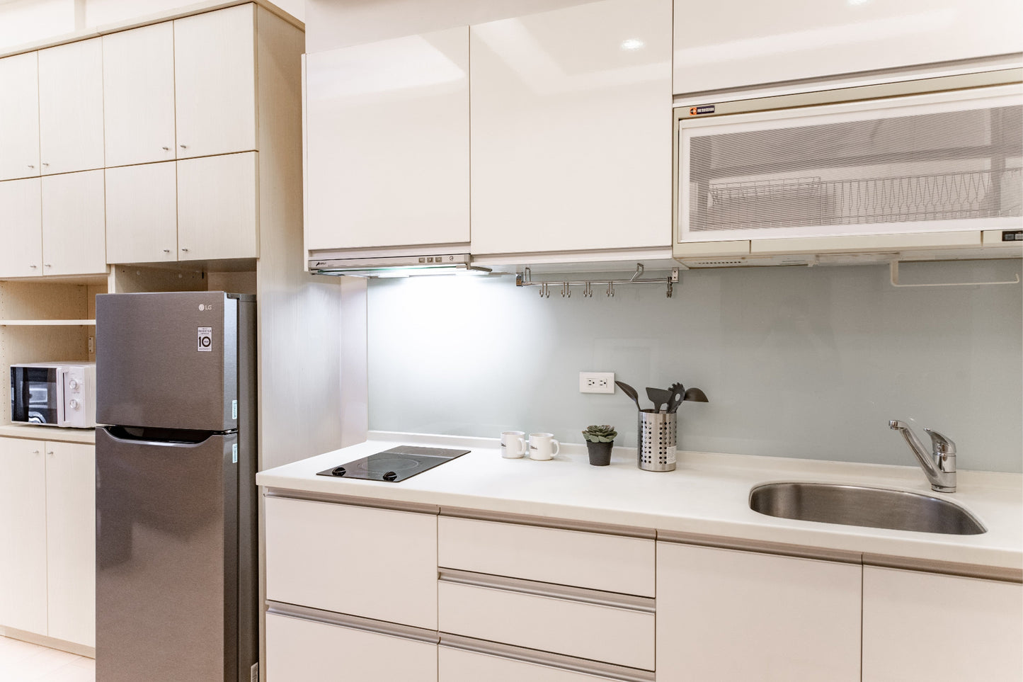 Fully-equipped modern kitchen by Kolette Home with marble countertop and induction stove for expat living.