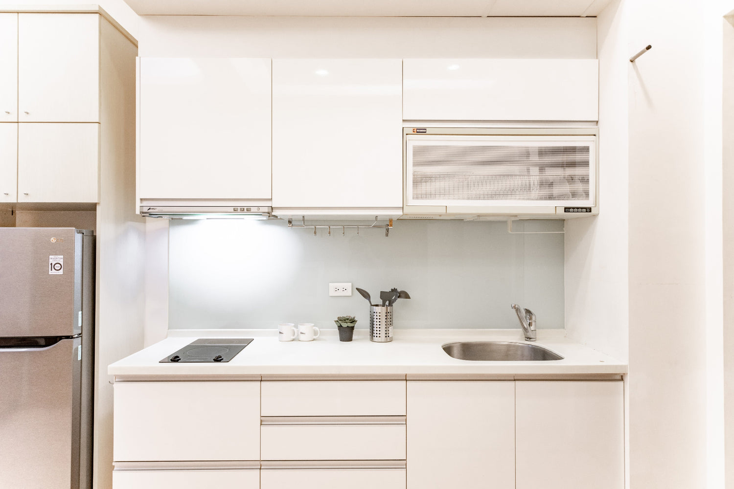 Fully-equipped modern kitchen by Kolette Home with marble countertop and induction stove for expat living.